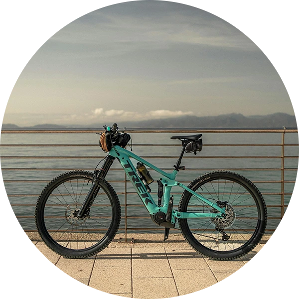  A Trek mountain bike with a large body of water and mountains behind it.